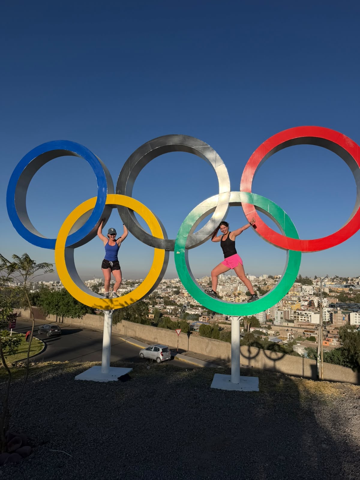 Two Run Club participants posing at the Olympic rings overlooking Arequipa