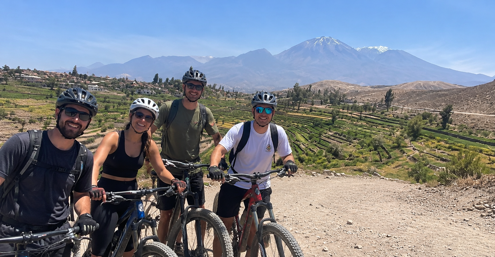 Smiling cyclist in red helmet with Andean mountains in the Arequipa countryside