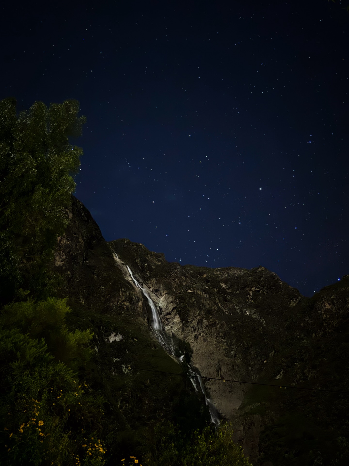 Nighttime waterfall beneath a starry sky in the Andes
