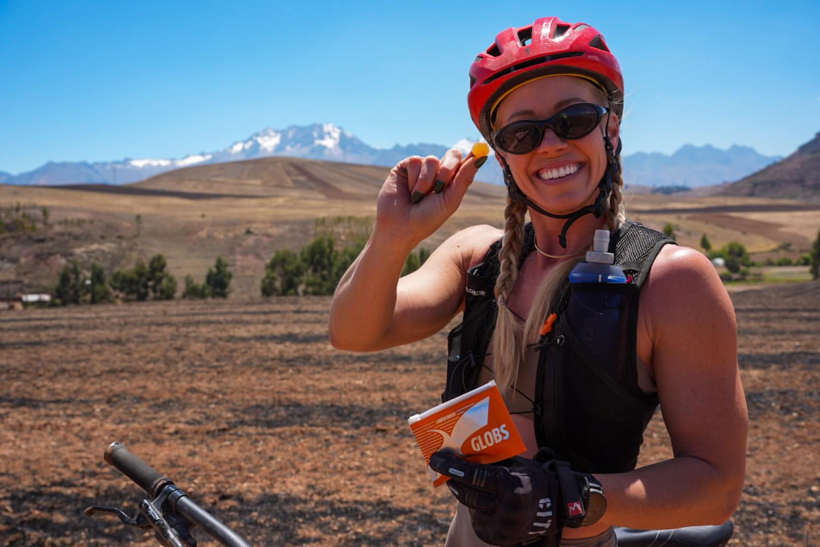Smiling cyclist in red helmet with Andean mountains in the Arequipa countryside
